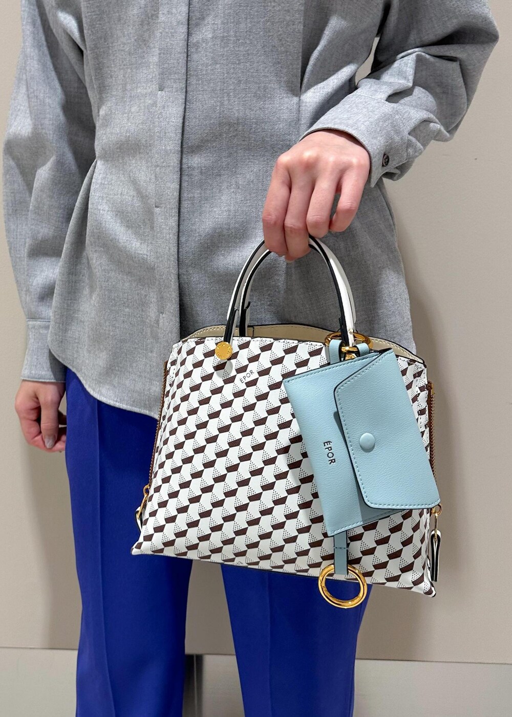 ホワイト系のショルダーバッグ、ブラック系のチェスターコート、グレー系のシャツ/ブラウスを着用したレディースの冬コーディネートの8枚目の写真