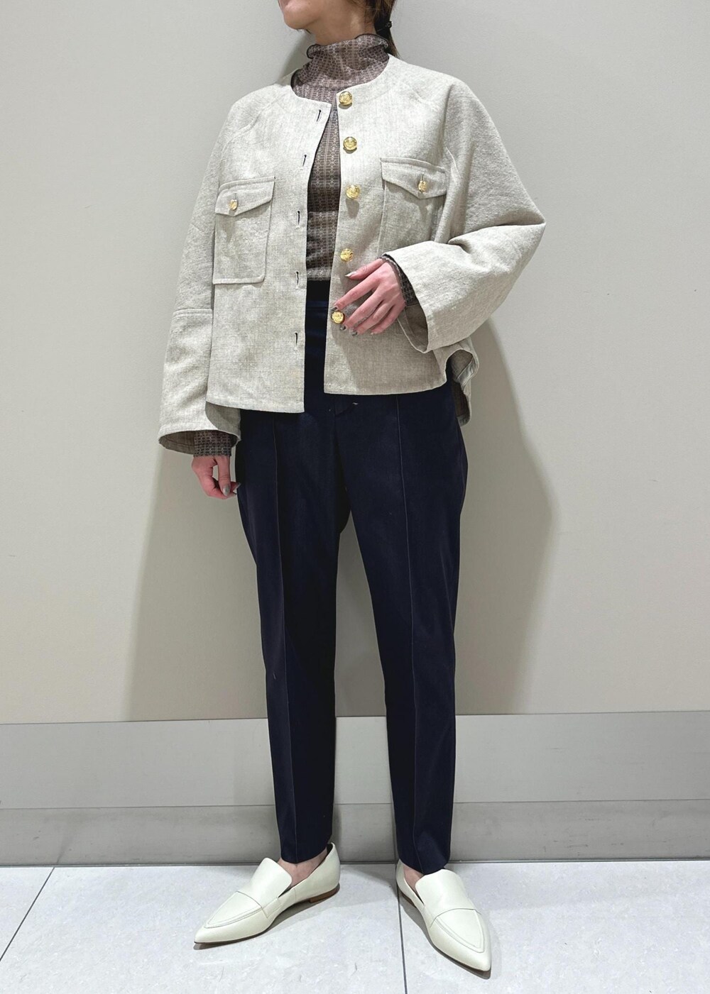 ホワイト系のパンプス、ベージュ系のブルゾン、ブラウン系のTシャツ/カットソーを着用したレディースの冬コーディネートの4枚目の写真