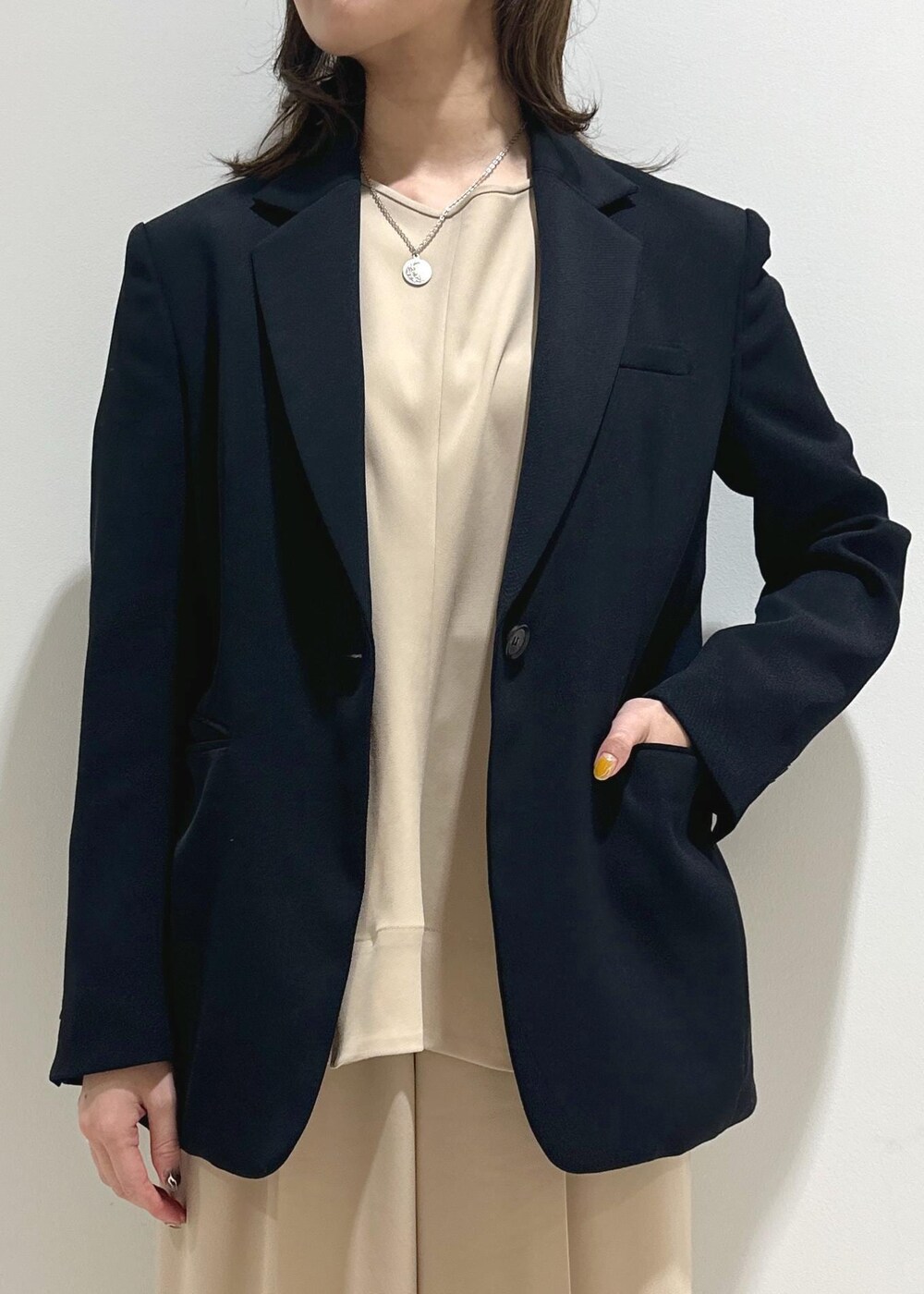 ブルー系のテーラードジャケット、ブラック系のパンプス、ブラック系のトートバッグを着用したレディースの春コーディネートの5枚目の写真