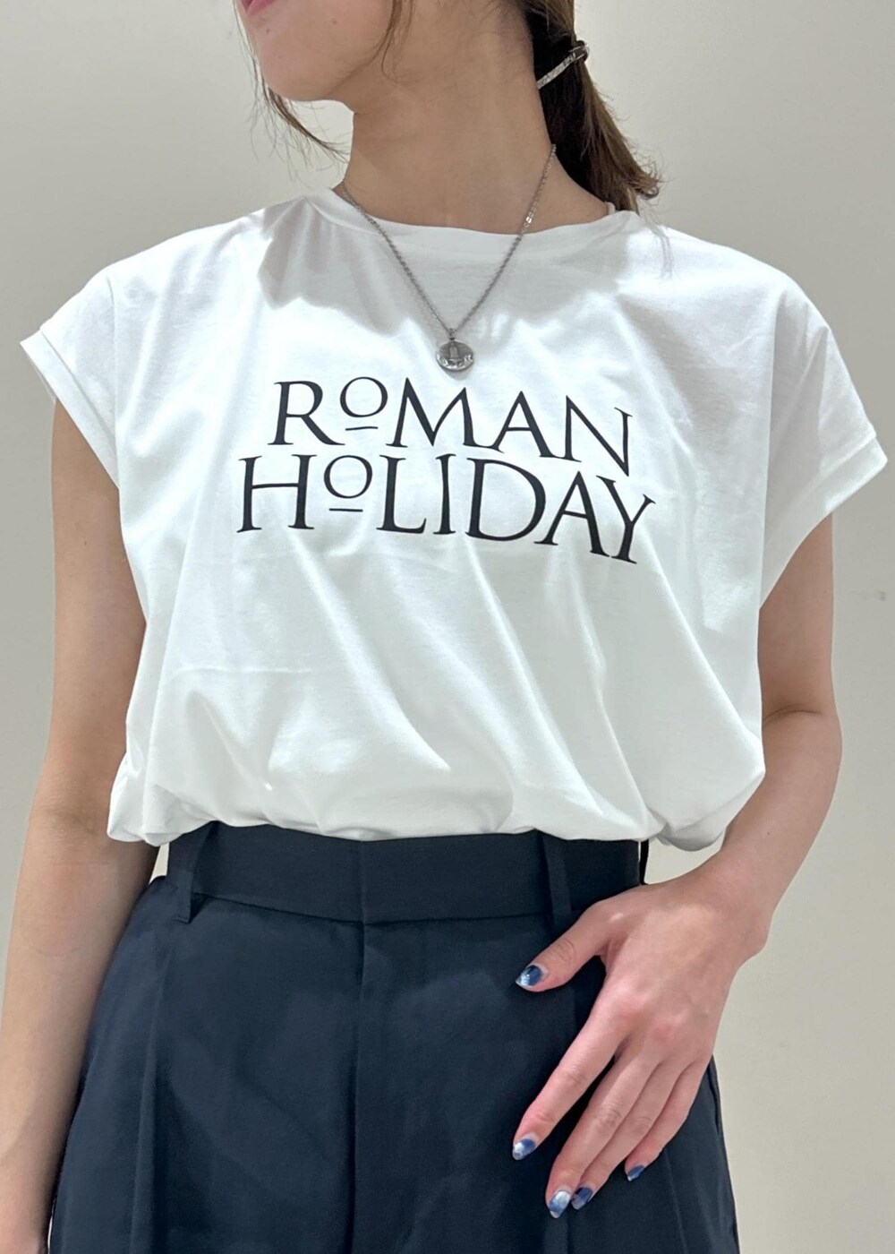 ホワイト系のハンドバッグ、ブラック系のサンダル、ブルー系のその他パンツを着用したレディースの夏コーディネートの5枚目の写真