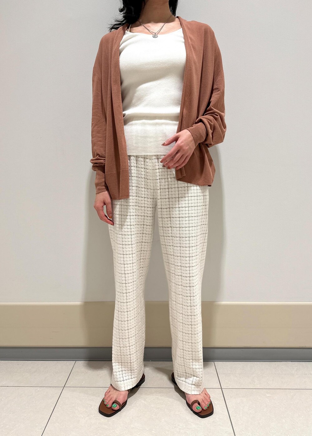 ホワイト系のハンドバッグ、イエロー系のサンダル、ホワイト系のその他パンツを着用したレディースの春コーディネートの4枚目の写真