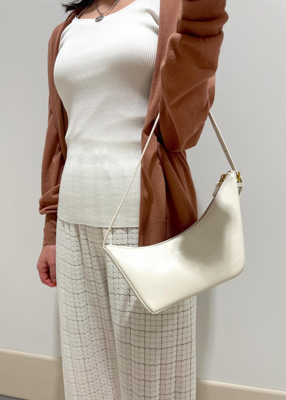 ホワイト系のハンドバッグ、イエロー系のサンダル、ホワイト系のその他パンツを着用したレディースの春コーディネートの8枚目の写真