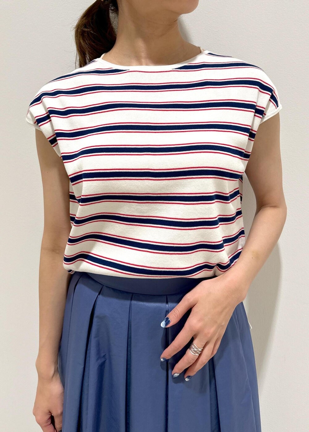 ホワイト系のハンドバッグ、ホワイト系のパンプス、ホワイト系のニット/セーターを着用したレディースの夏コーディネートの5枚目の写真