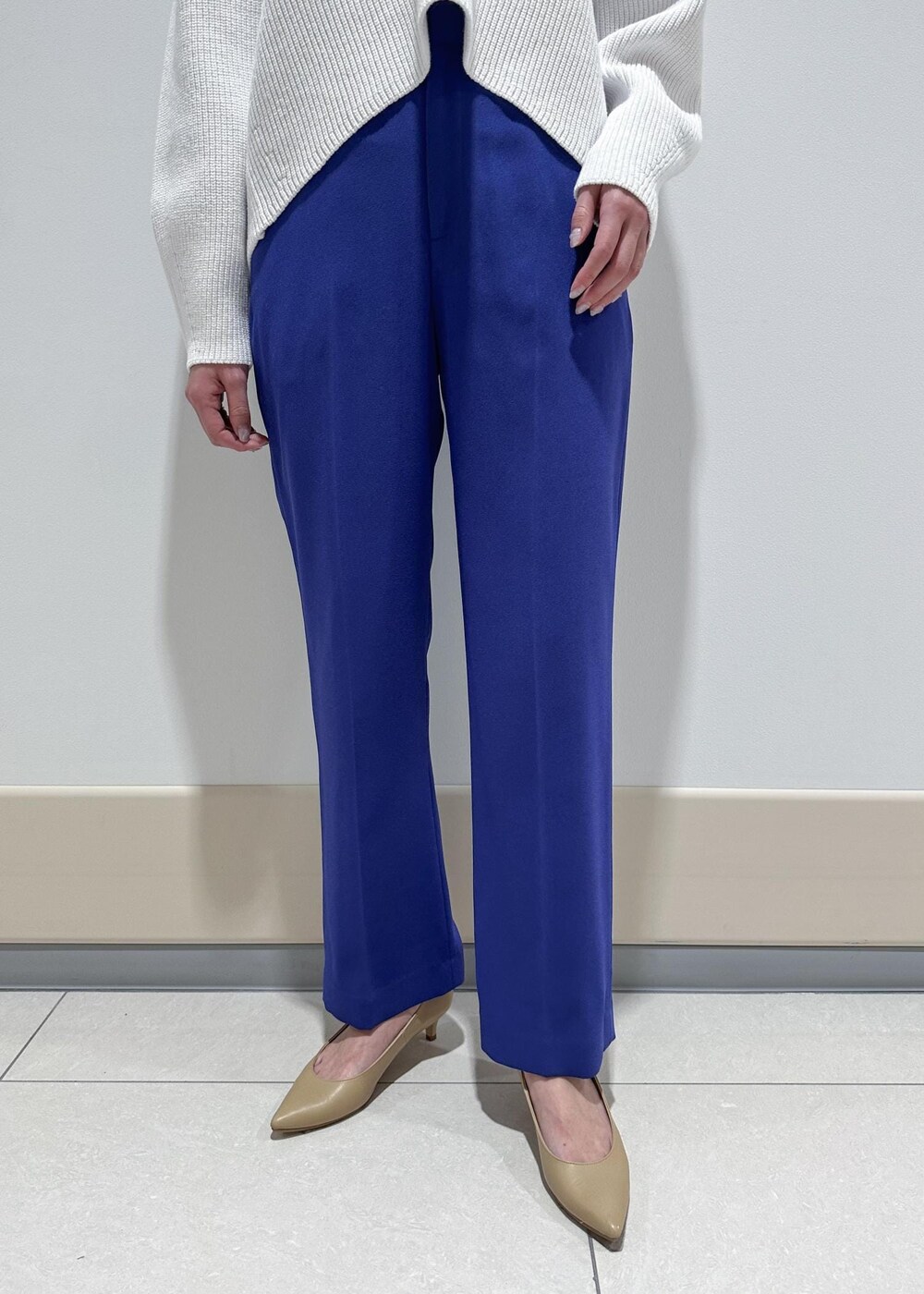 ベージュ系のパンプス、ホワイト系のトートバッグ、ブルー系のその他パンツを着用したレディースの冬コーディネートの6枚目の写真