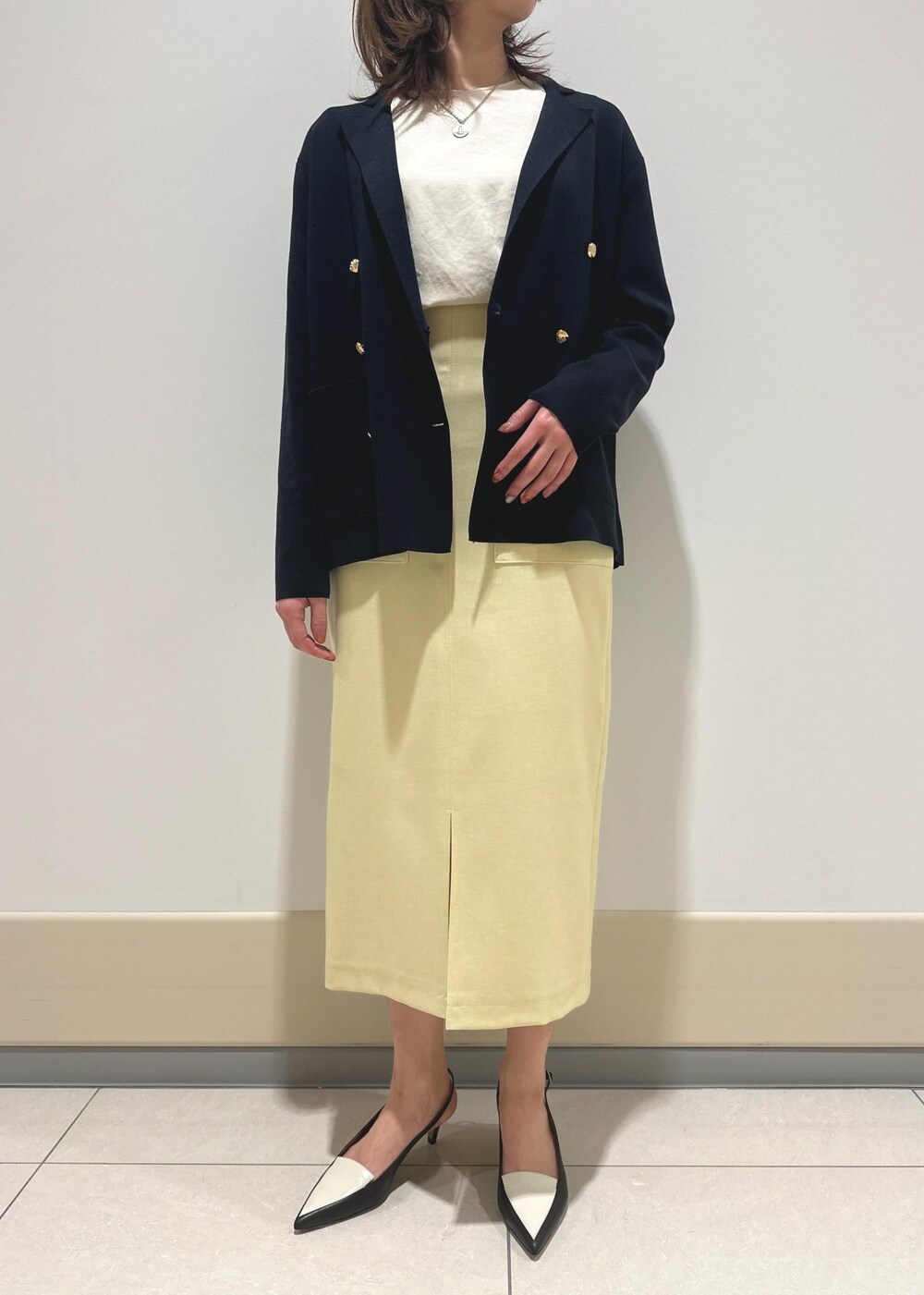 ブラック系のパンプス、ベージュ系のスカート、ピンク系のTシャツ/カットソーを着用したレディースの春コーディネートの4枚目の写真