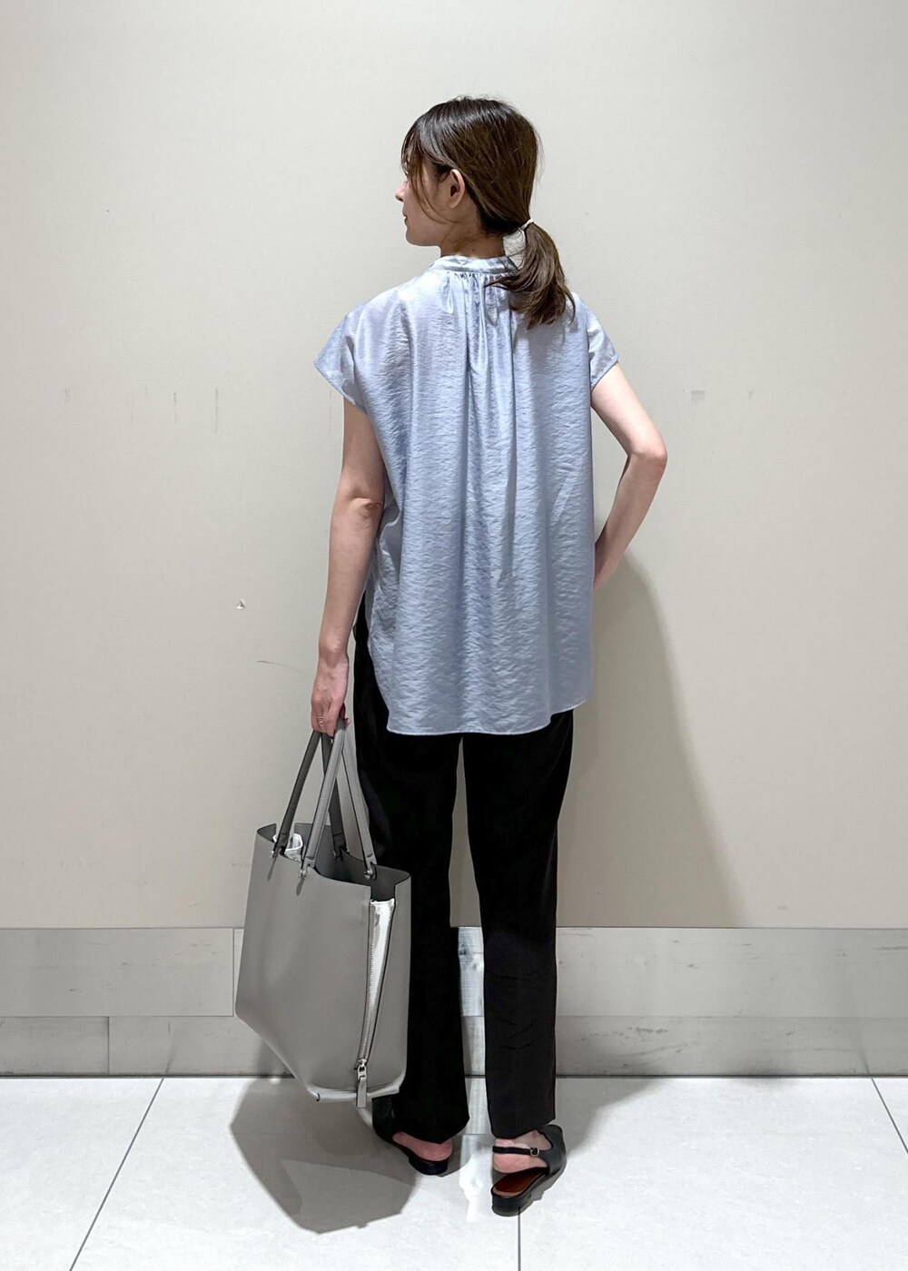 グレー系のトートバッグ、ブラック系のパンプス、ブラウン系のその他パンツを着用したレディースの夏コーディネートの3枚目の写真