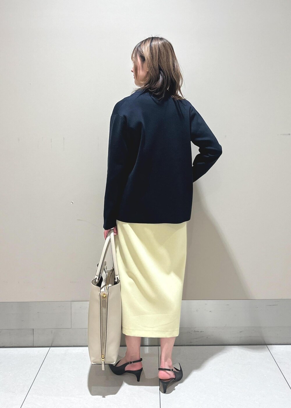 ブラック系のパンプス、ベージュ系のスカート、ピンク系のTシャツ/カットソーを着用したレディースの春コーディネートの3枚目の写真