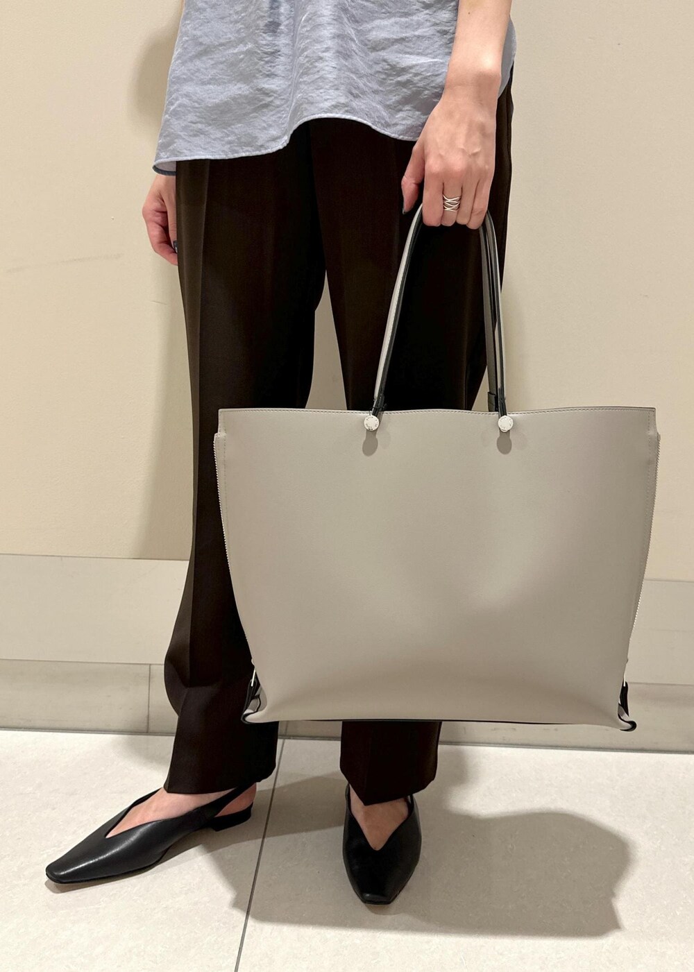 グレー系のトートバッグ、ブラック系のパンプス、ブラウン系のその他パンツを着用したレディースの夏コーディネートの7枚目の写真