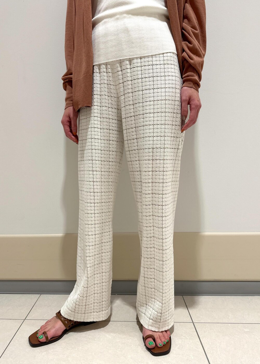 ホワイト系のハンドバッグ、イエロー系のサンダル、ホワイト系のその他パンツを着用したレディースの春コーディネートの6枚目の写真