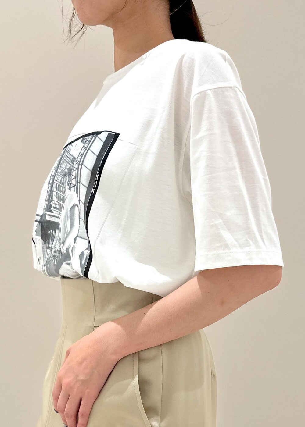 ブラック系のハンドバッグ、ブラック系のサンダル、ベージュ系のスカートを着用したレディースの夏コーディネートの6枚目の写真