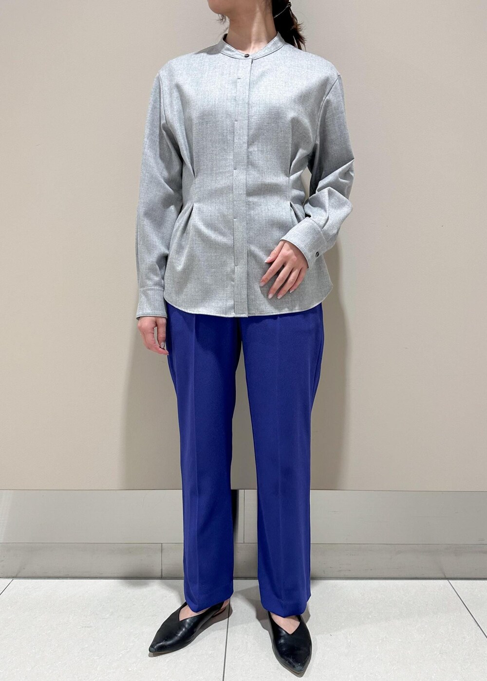 ホワイト系のショルダーバッグ、ブラック系のチェスターコート、グレー系のシャツ/ブラウスを着用したレディースの冬コーディネートの6枚目の写真