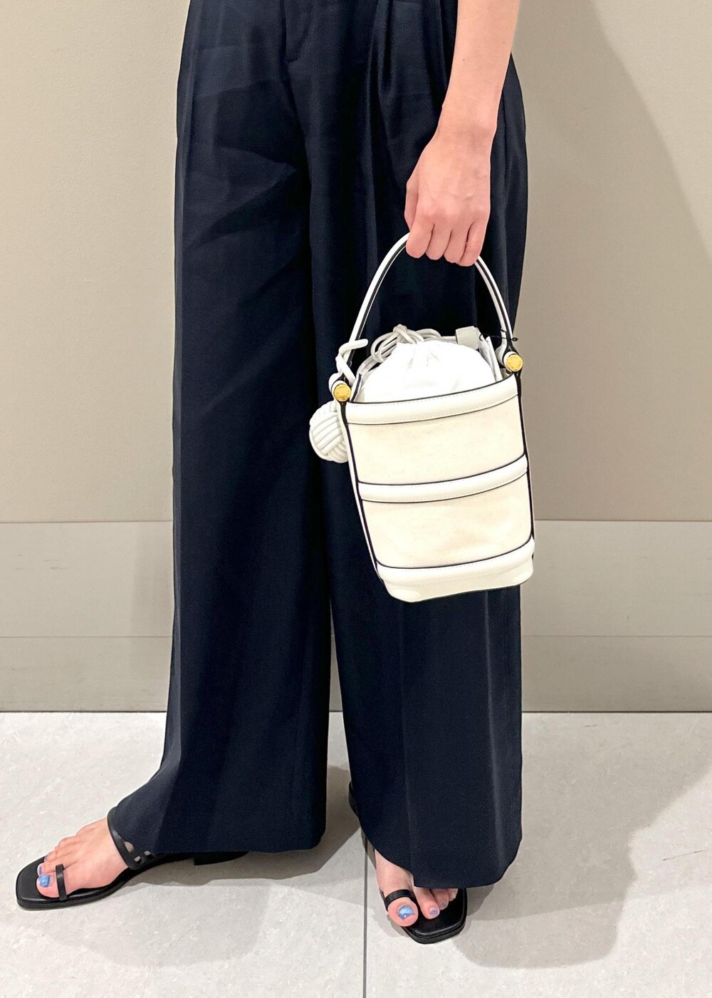 ホワイト系のハンドバッグ、ブラック系のサンダル、ブルー系のその他パンツを着用したレディースの夏コーディネートの8枚目の写真