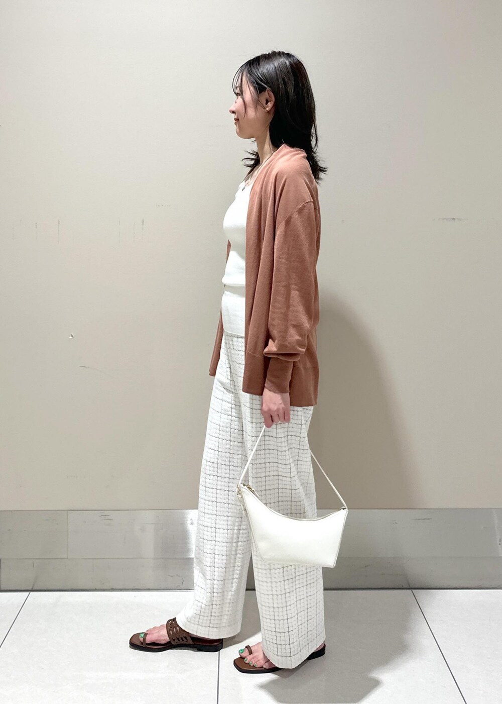 ホワイト系のハンドバッグ、イエロー系のサンダル、ホワイト系のその他パンツを着用したレディースの春コーディネートの2枚目の写真