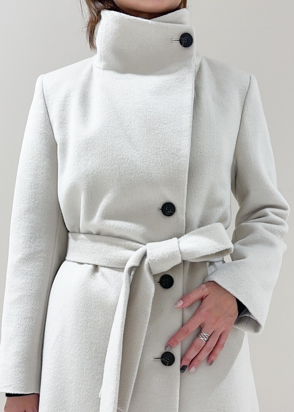 オレンジ系のハンドバッグ、ホワイト系のチェスターコート、グレー系のその他パンツを着用したレディースの秋コーディネートの8枚目の写真