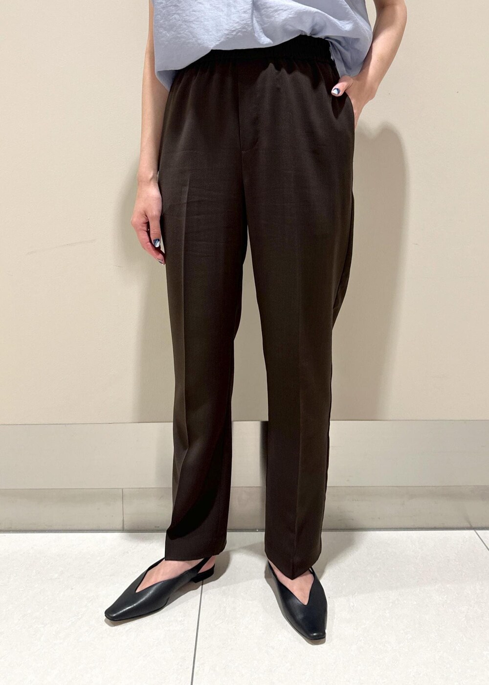 グレー系のトートバッグ、ブラック系のパンプス、ブラウン系のその他パンツを着用したレディースの夏コーディネートの6枚目の写真