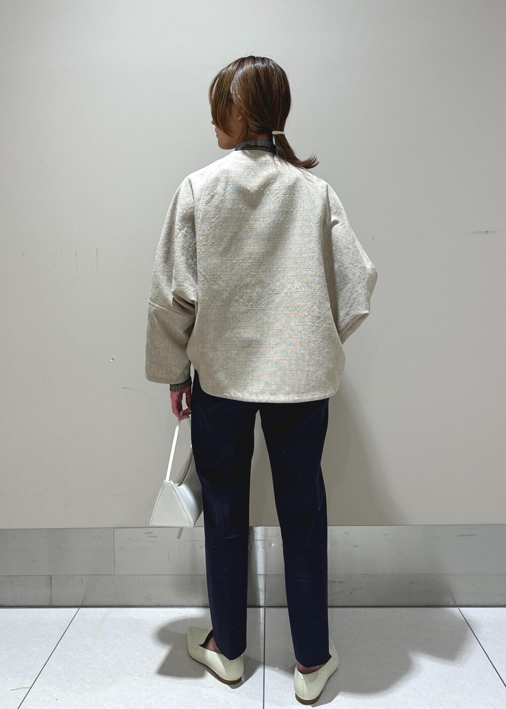 ホワイト系のパンプス、ベージュ系のブルゾン、ブラウン系のTシャツ/カットソーを着用したレディースの冬コーディネートの3枚目の写真