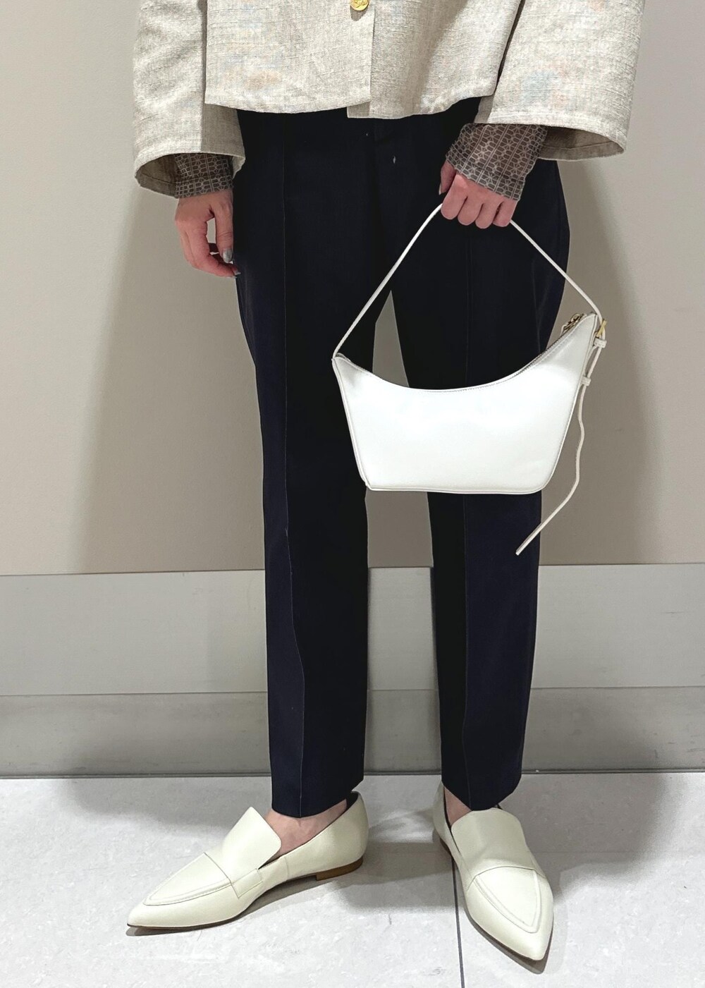 ホワイト系のパンプス、ベージュ系のブルゾン、ブラウン系のTシャツ/カットソーを着用したレディースの冬コーディネートの8枚目の写真