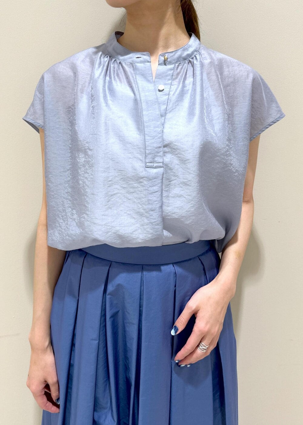 ホワイト系のハンドバッグ、シルバー系のパンプス、ブルー系のシャツ/ブラウスを着用したレディースの夏コーディネートの5枚目の写真