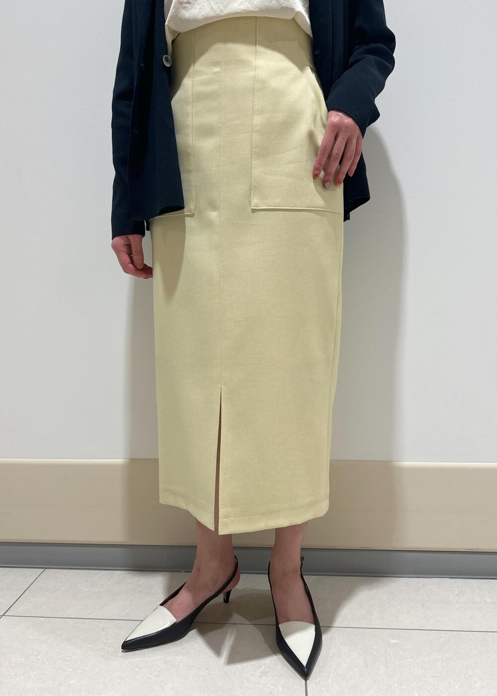 ブラック系のパンプス、ベージュ系のスカート、ピンク系のTシャツ/カットソーを着用したレディースの春コーディネートの8枚目の写真