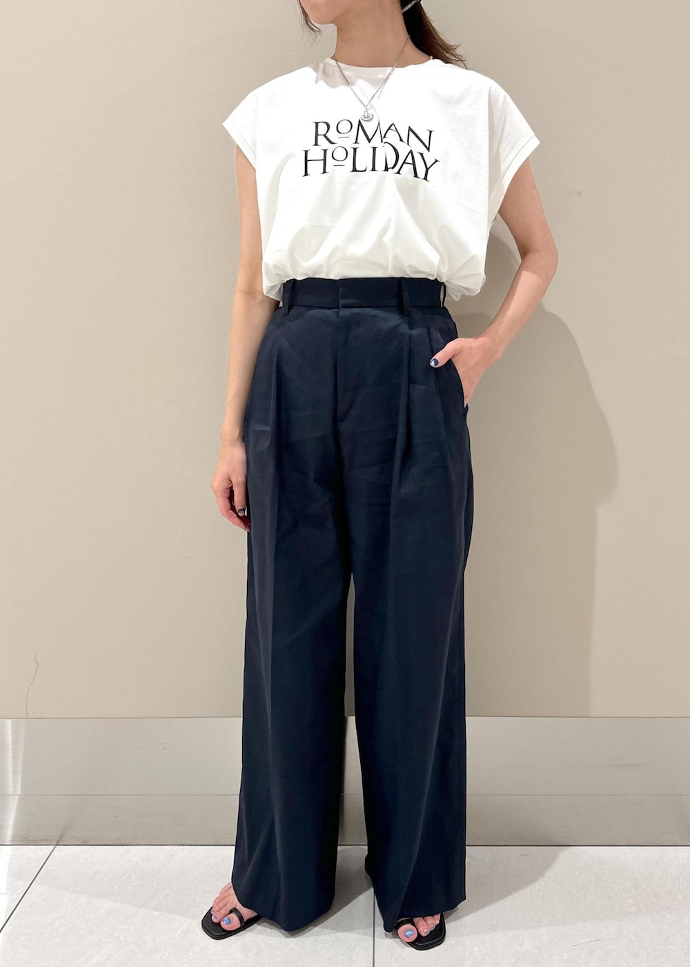 ホワイト系のハンドバッグ、ブラック系のサンダル、ブルー系のその他パンツを着用したレディースの夏コーディネートの4枚目の写真