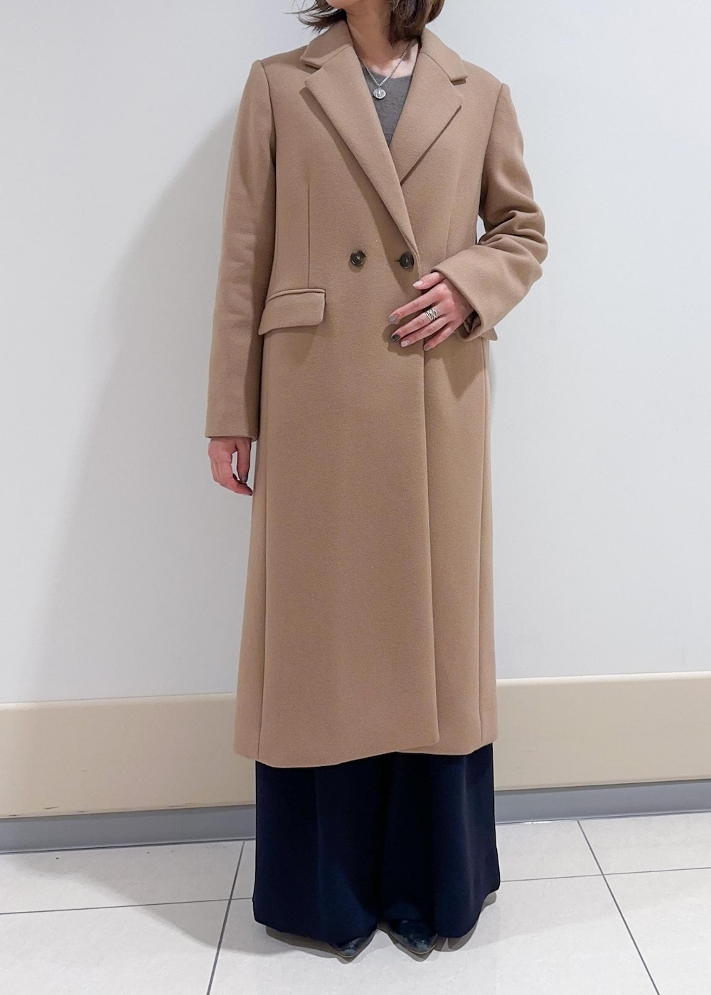 ブラック系のトートバッグ、イエロー系のチェスターコート、ブラウン系のニット/セーターを着用したレディースの秋コーディネートの5枚目の写真