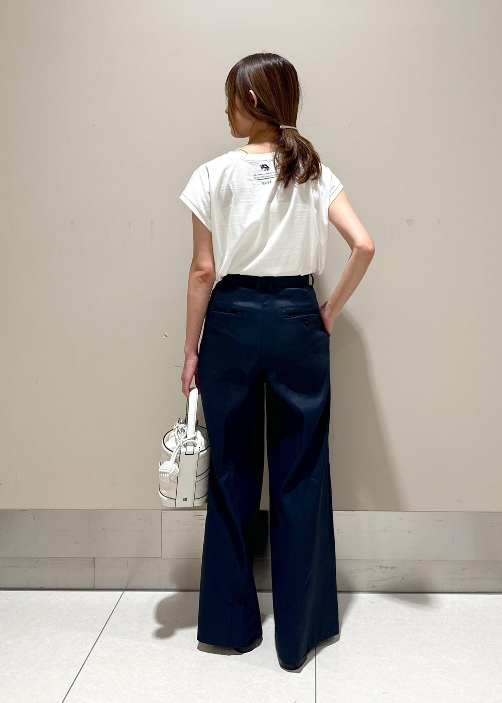 ホワイト系のハンドバッグ、ブラック系のサンダル、ブルー系のその他パンツを着用したレディースの夏コーディネートの3枚目の写真