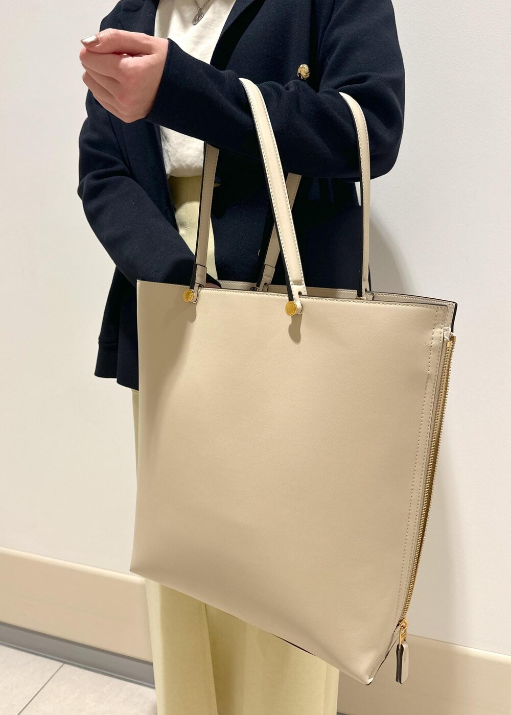 ブラック系のパンプス、ベージュ系のスカート、ピンク系のTシャツ/カットソーを着用したレディースの春コーディネートの9枚目の写真