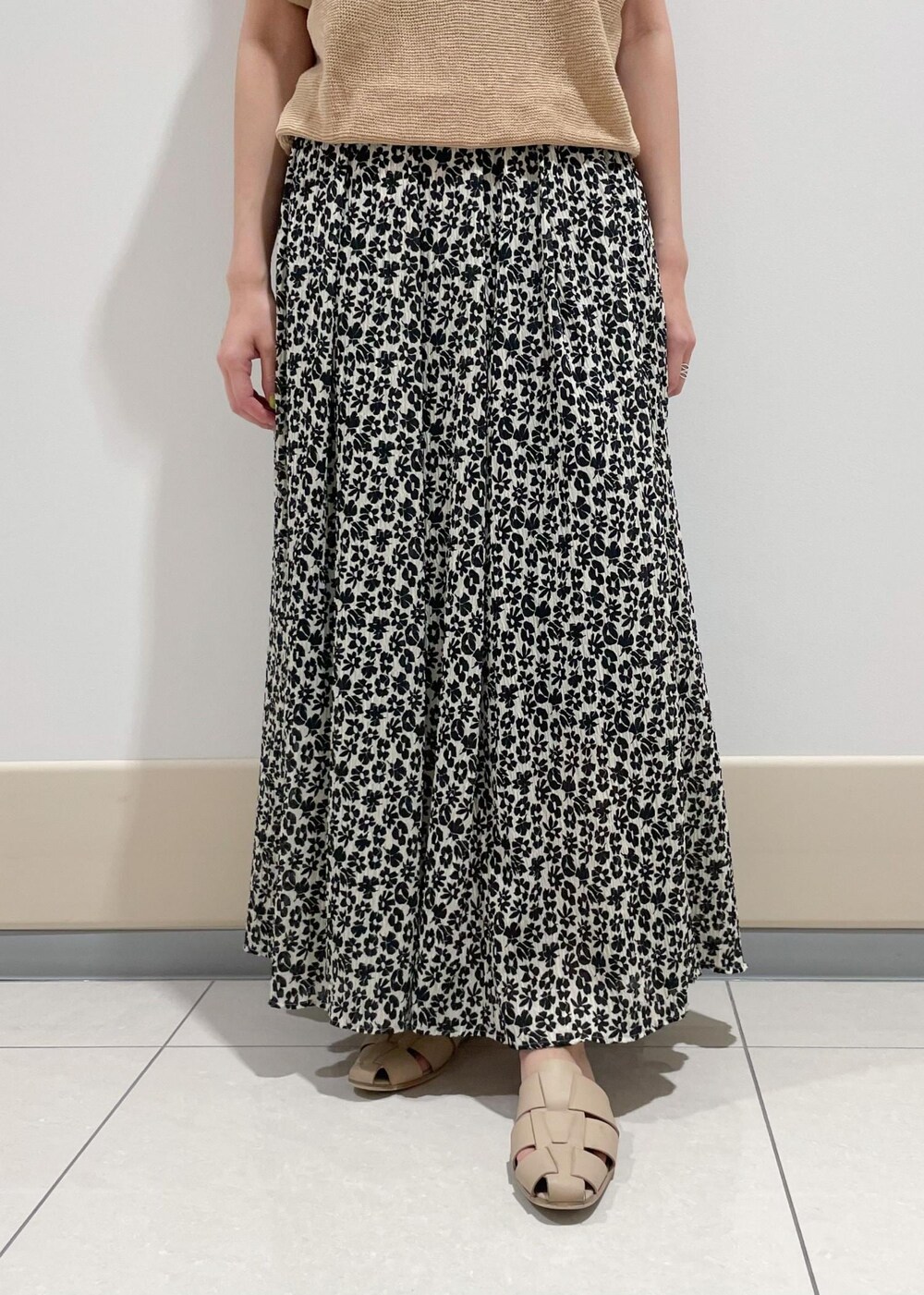 ブラック系のハンドバッグ、ベージュ系のTシャツ/カットソー、ブラック系のスカートを着用したレディースの夏コーディネートの5枚目の写真