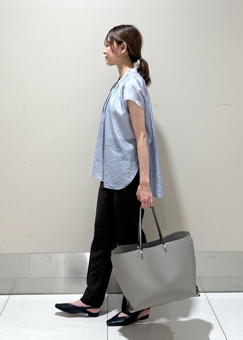 グレー系のトートバッグ、ブラック系のパンプス、ブラウン系のその他パンツを着用したレディースの夏コーディネートの2枚目の写真