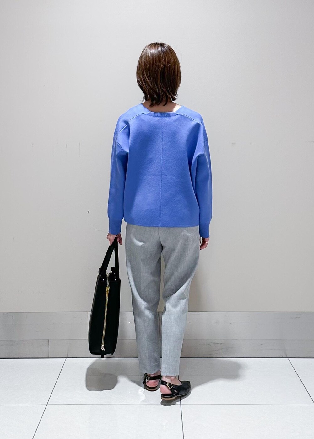 ブラック系のトートバッグ、ブルー系のニット/セーター、グレー系のその他パンツを着用したレディースの秋コーディネートの3枚目の写真