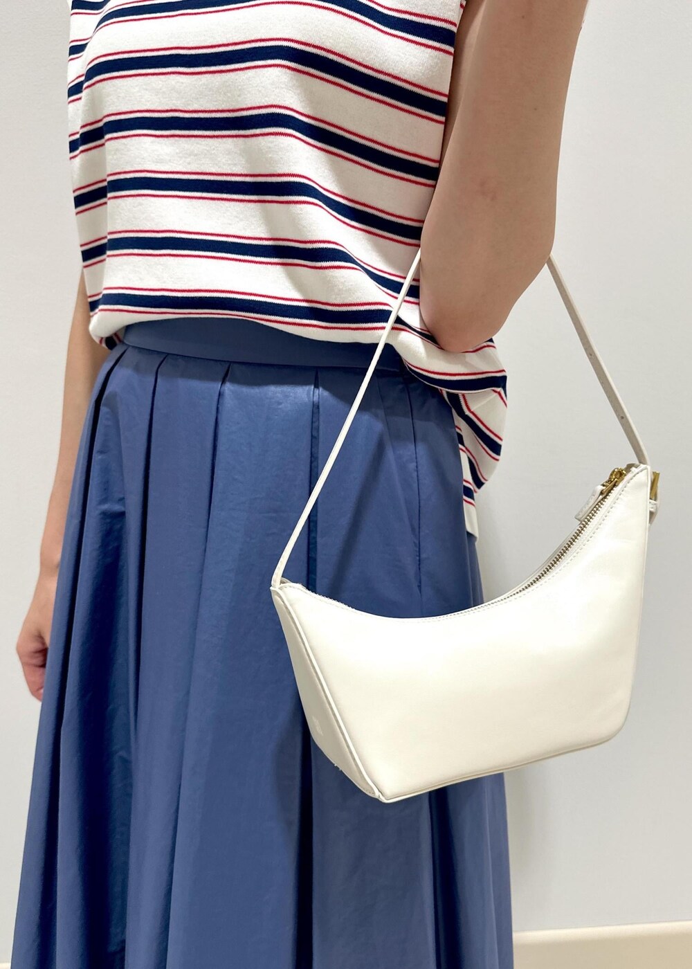 ホワイト系のハンドバッグ、ホワイト系のパンプス、ホワイト系のニット/セーターを着用したレディースの夏コーディネートの7枚目の写真