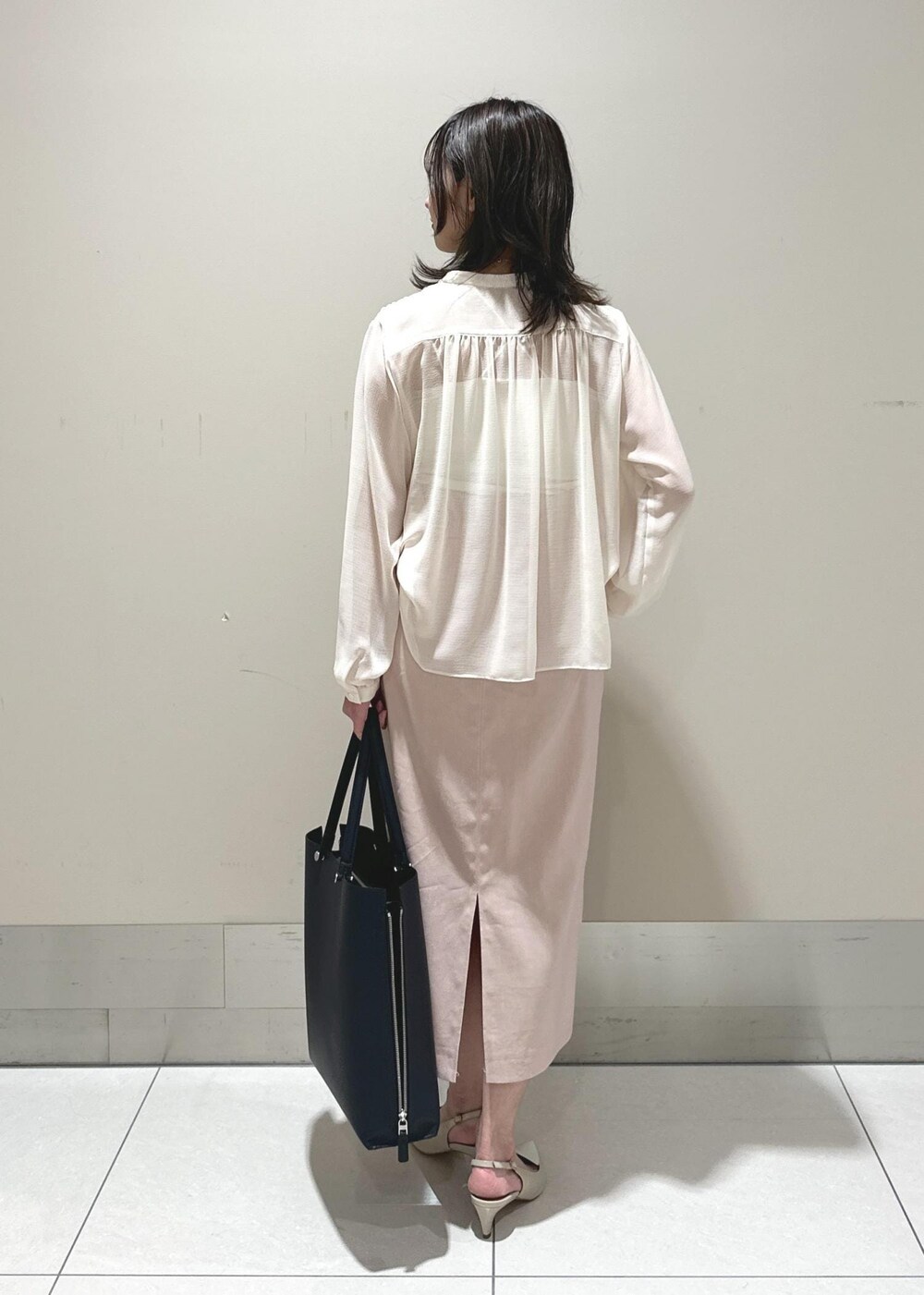 ブルー系のトートバッグ、ベージュ系のパンプス、ホワイト系のシャツ/ブラウスを着用したレディースの春コーディネートの3枚目の写真