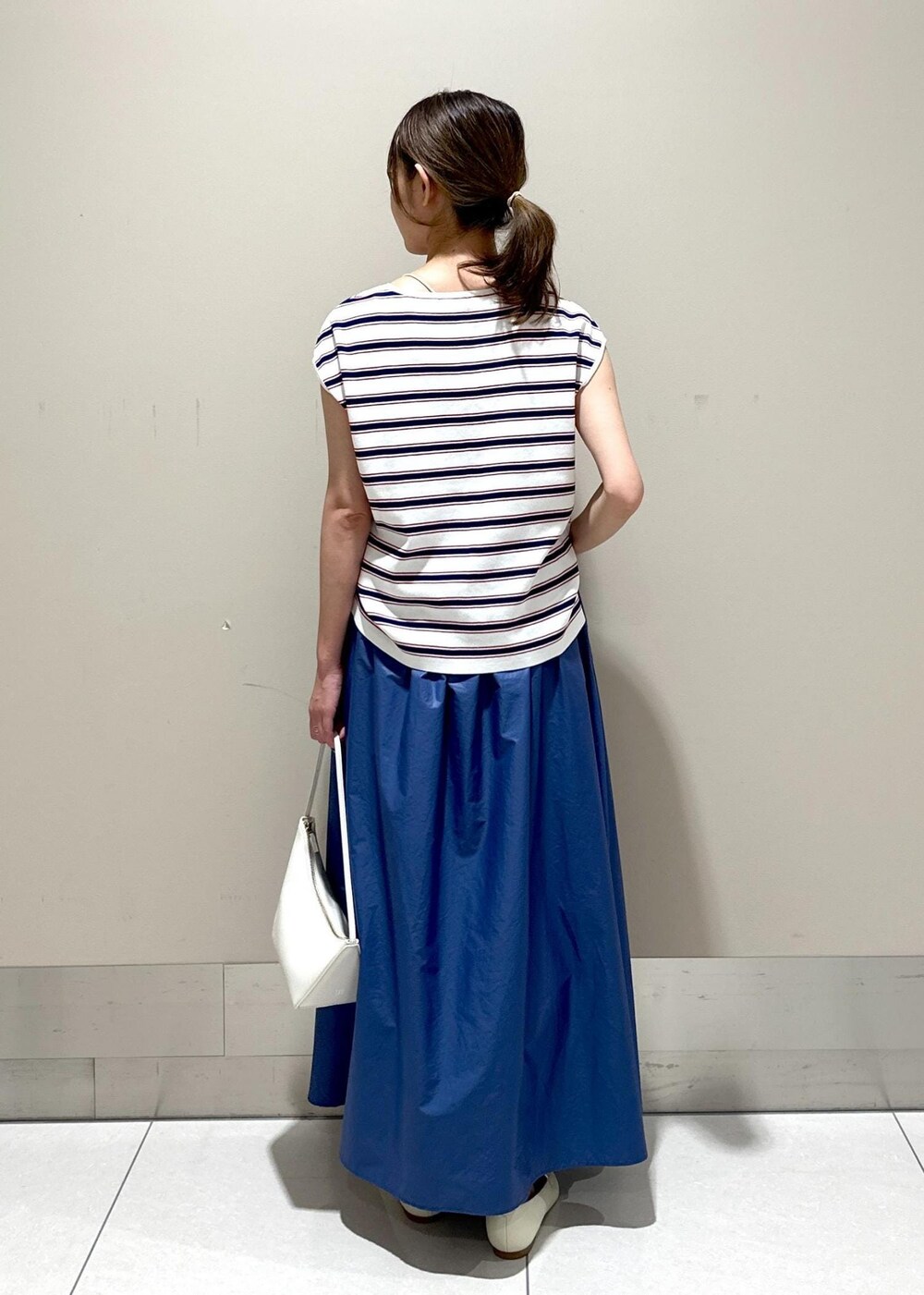 ホワイト系のハンドバッグ、ホワイト系のパンプス、ホワイト系のニット/セーターを着用したレディースの夏コーディネートの3枚目の写真