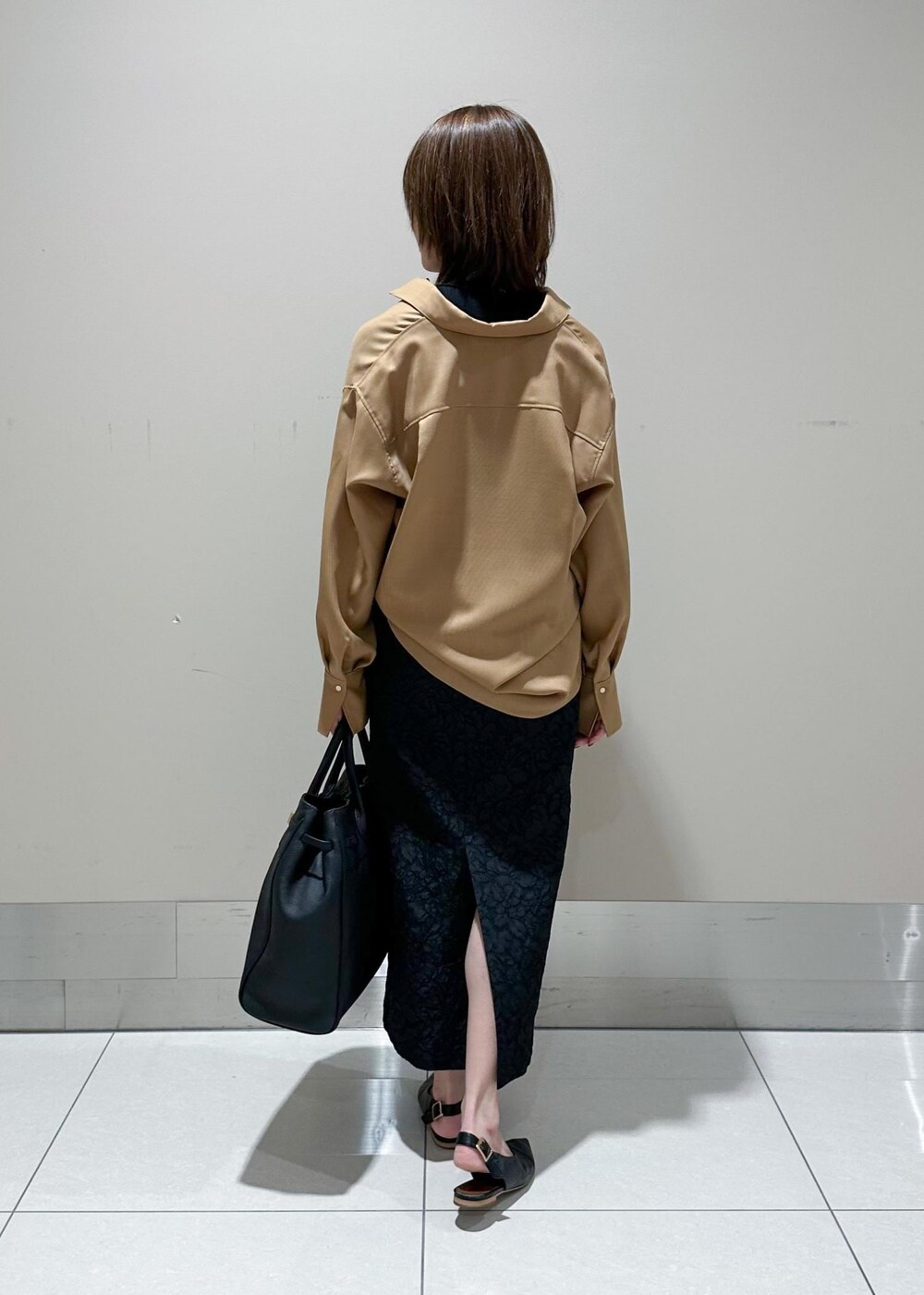 ブラック系のトートバッグ、ベージュ系のシャツ/ブラウス、ブラック系のニット/セーターを着用したレディースの秋コーディネートの3枚目の写真