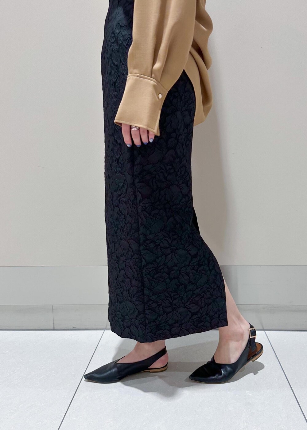 ブラック系のトートバッグ、ベージュ系のシャツ/ブラウス、ブラック系のニット/セーターを着用したレディースの秋コーディネートの8枚目の写真