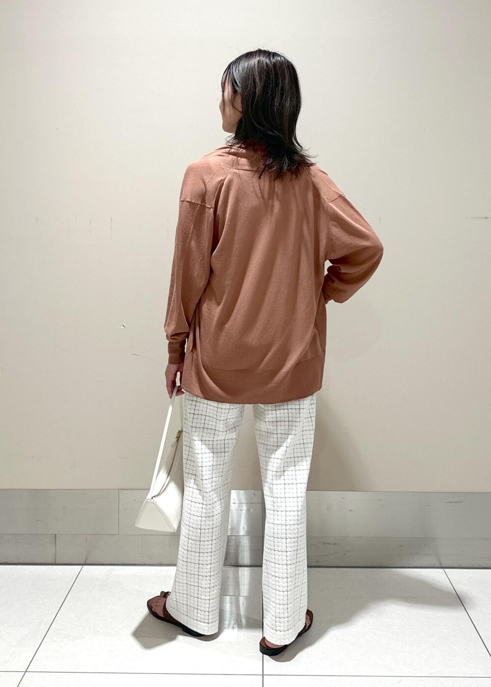 ホワイト系のハンドバッグ、イエロー系のサンダル、ホワイト系のその他パンツを着用したレディースの春コーディネートの3枚目の写真