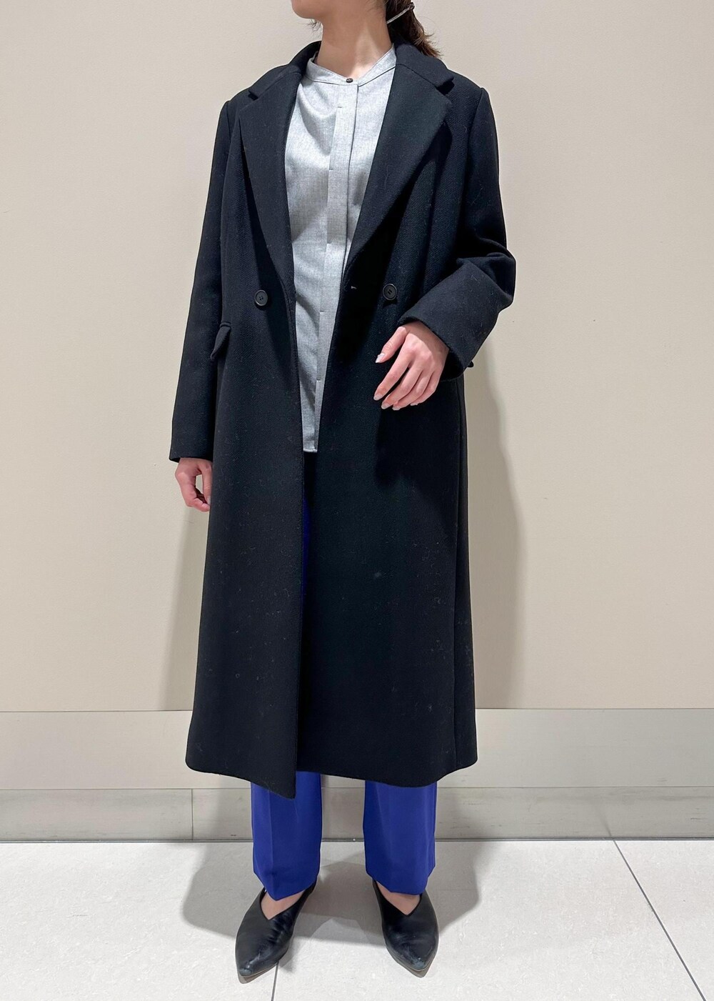 ホワイト系のショルダーバッグ、ブラック系のチェスターコート、グレー系のシャツ/ブラウスを着用したレディースの冬コーディネートの4枚目の写真