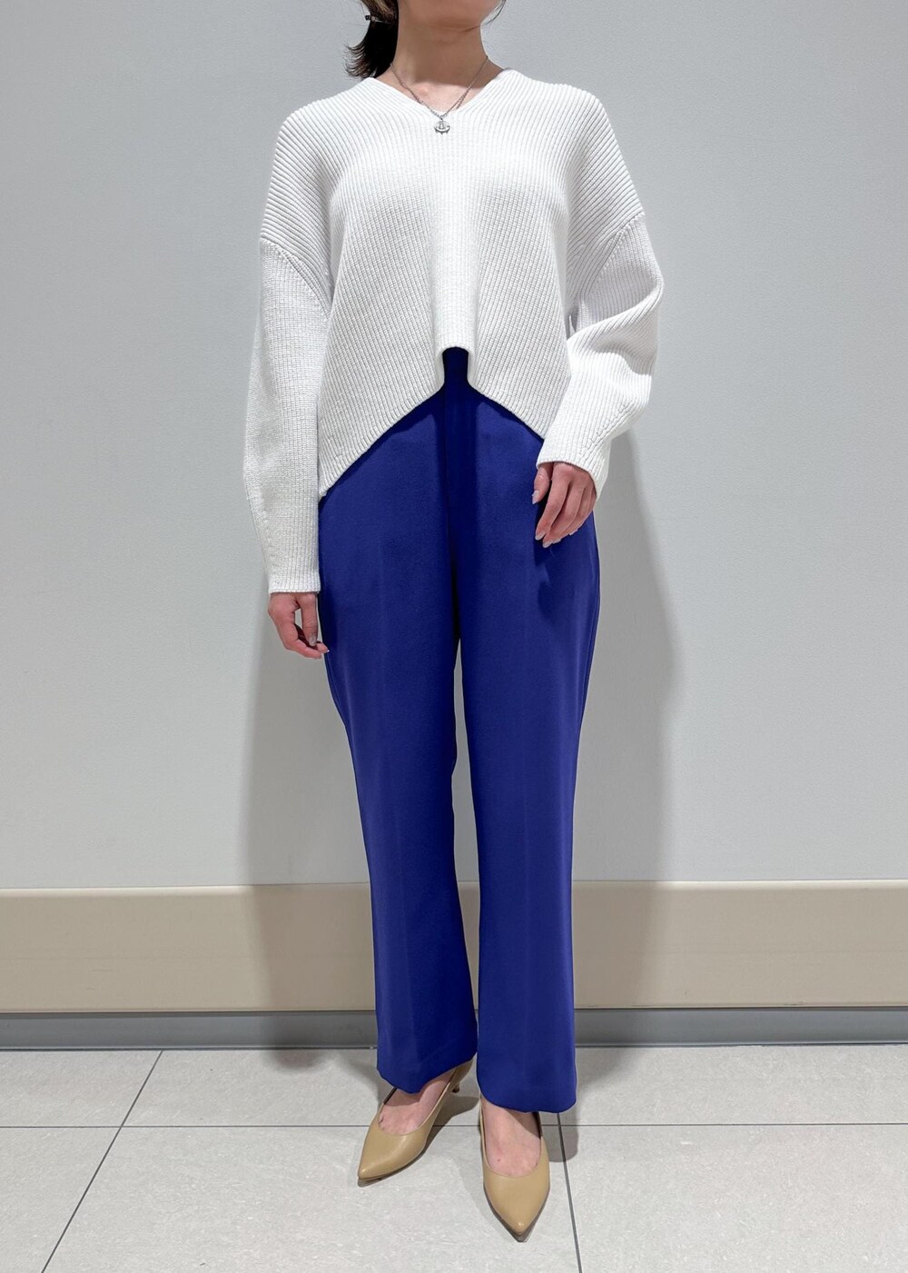 ベージュ系のパンプス、ホワイト系のトートバッグ、ブルー系のその他パンツを着用したレディースの冬コーディネートの4枚目の写真