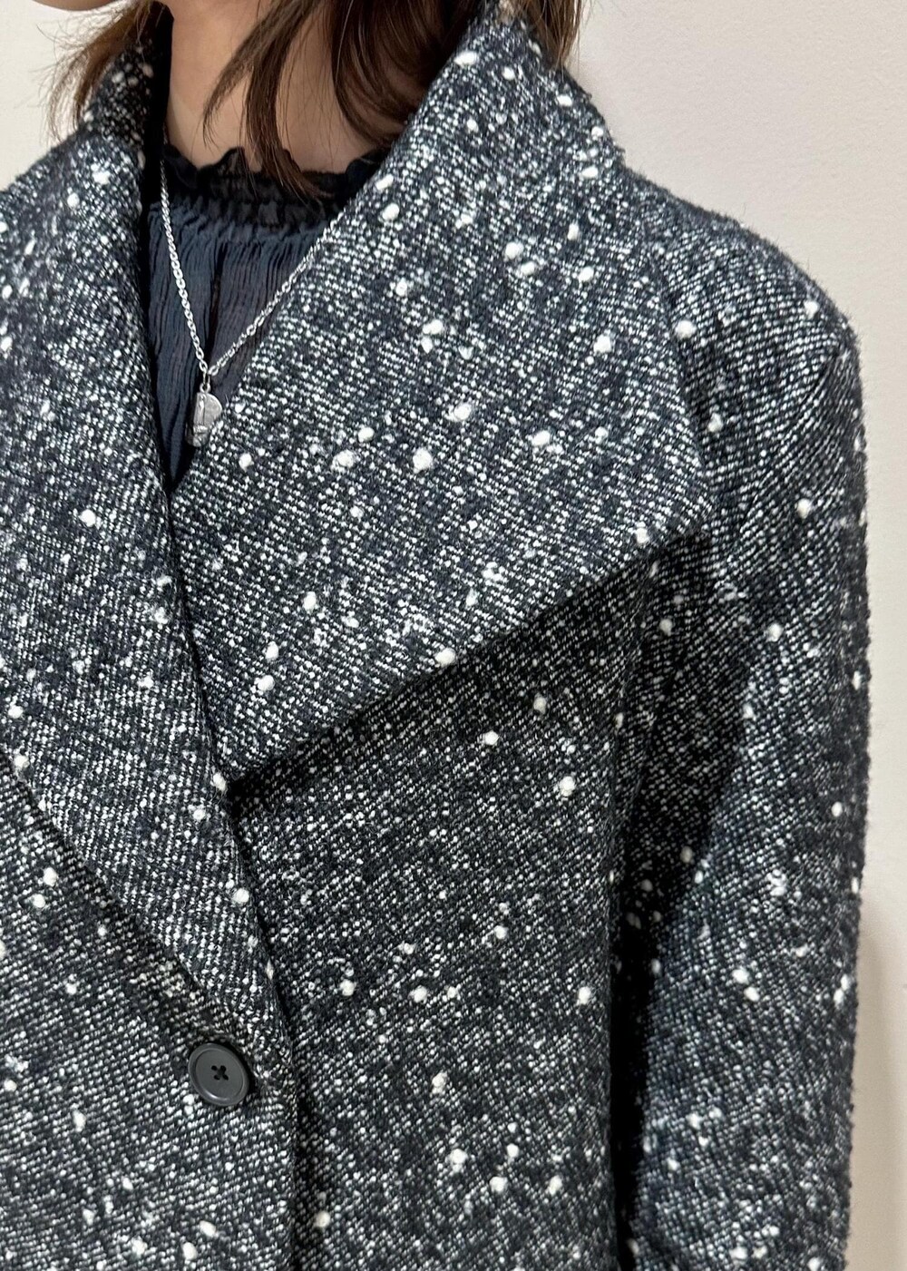 ベージュ系のハンドバッグ、ブラック系のブーツ、ブラック系のその他アウターを着用したレディースの冬コーディネートの6枚目の写真