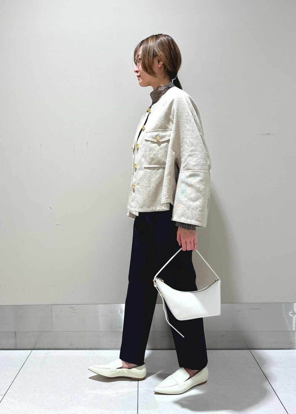 ホワイト系のパンプス、ベージュ系のブルゾン、ブラウン系のTシャツ/カットソーを着用したレディースの冬コーディネートの2枚目の写真