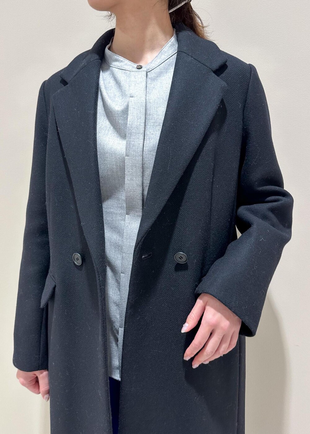 ホワイト系のショルダーバッグ、ブラック系のチェスターコート、グレー系のシャツ/ブラウスを着用したレディースの冬コーディネートの5枚目の写真