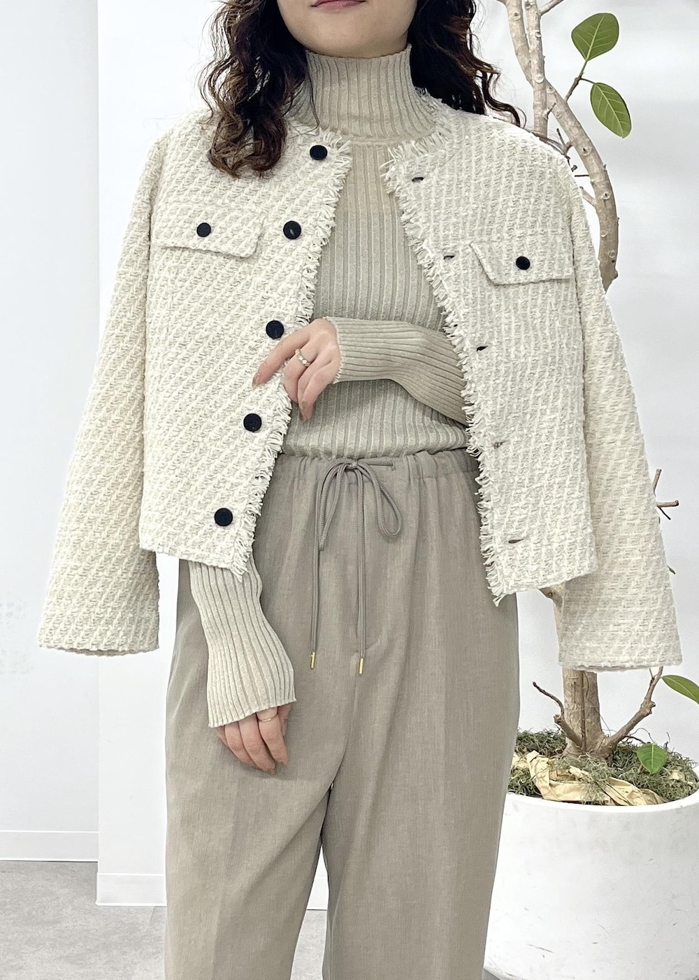 ベージュ系のニット/セーター、ベージュ系のその他パンツ、ホワイト系のノーカラージャケットを着用したレディースの冬コーディネートの5枚目の写真