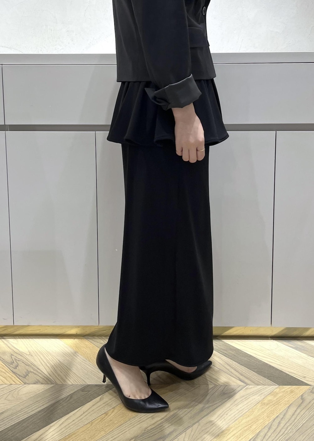 ブラック系のキャミソール、ブラック系のテーラードジャケット、ブラック系のスカートを着用したレディースの秋コーディネートの8枚目の写真