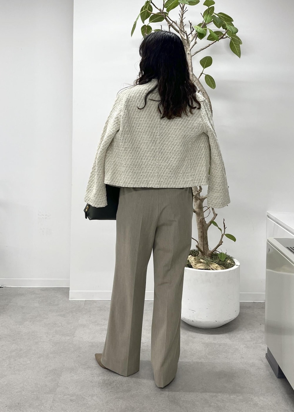 ベージュ系のニット/セーター、ベージュ系のその他パンツ、ホワイト系のノーカラージャケットを着用したレディースの冬コーディネートの4枚目の写真