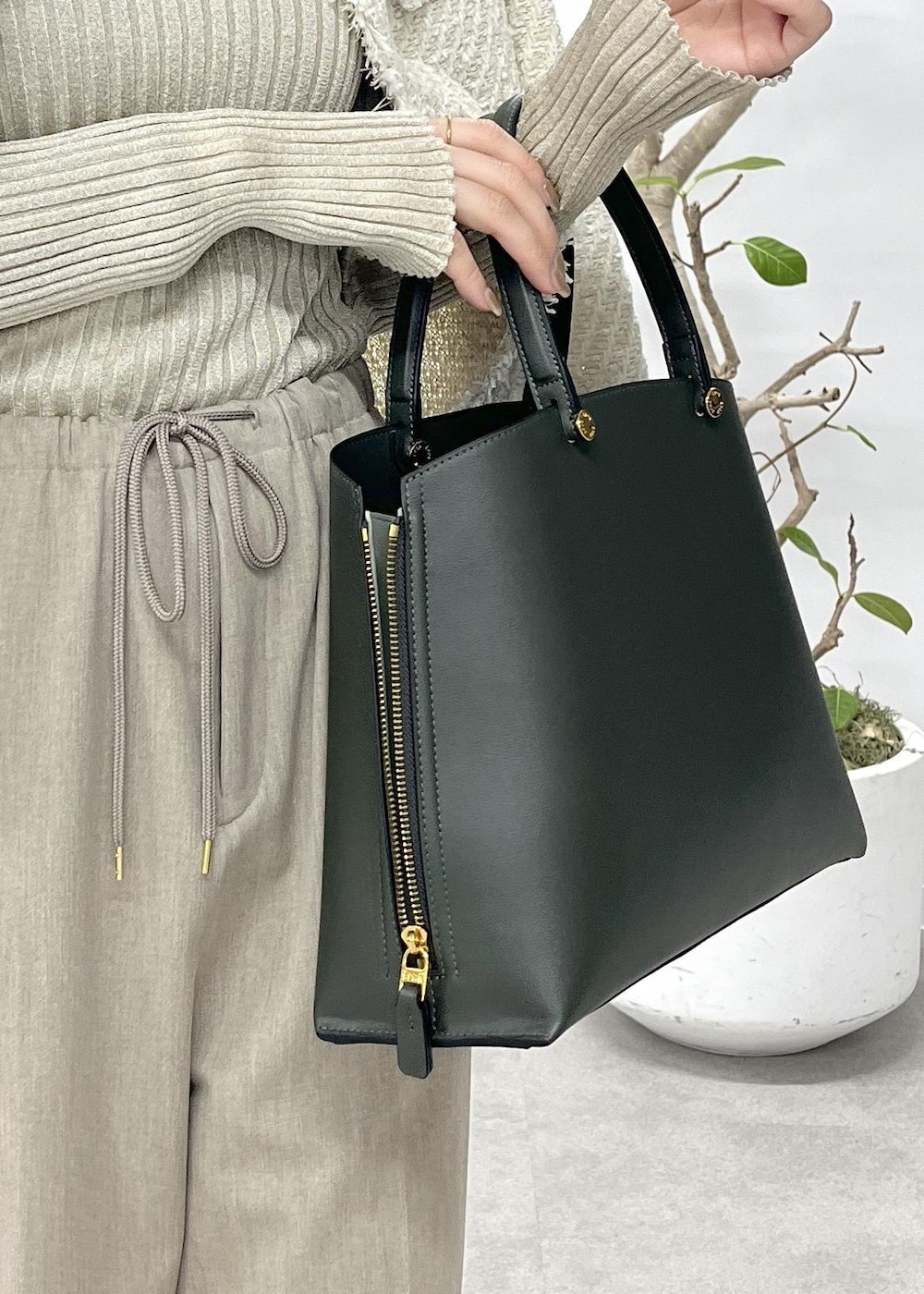 ベージュ系のニット/セーター、ベージュ系のその他パンツ、ホワイト系のノーカラージャケットを着用したレディースの冬コーディネートの8枚目の写真