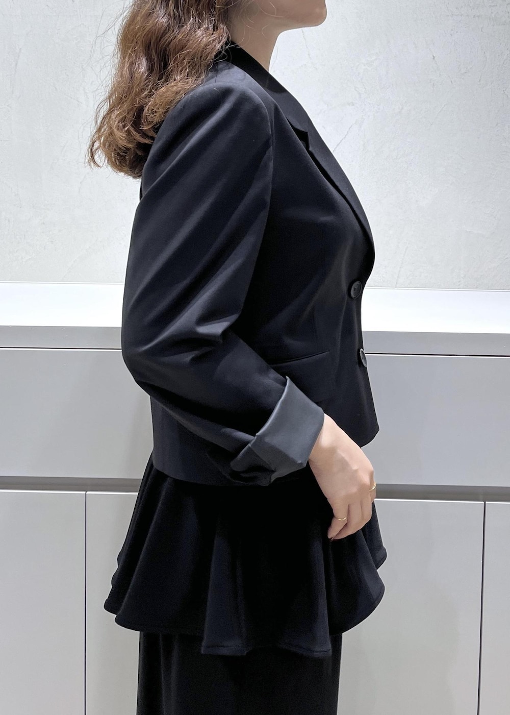 ブラック系のキャミソール、ブラック系のテーラードジャケット、ブラック系のスカートを着用したレディースの秋コーディネートの6枚目の写真