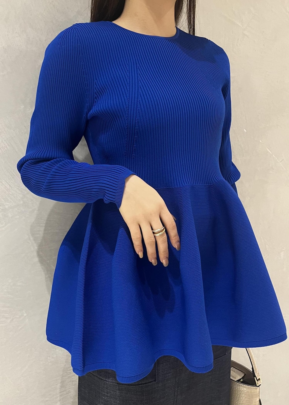 ベージュ系のパンプス、ベージュ系のショルダーバッグ、ブルー系のニット/セーターを着用したレディースの冬コーディネートの5枚目の写真
