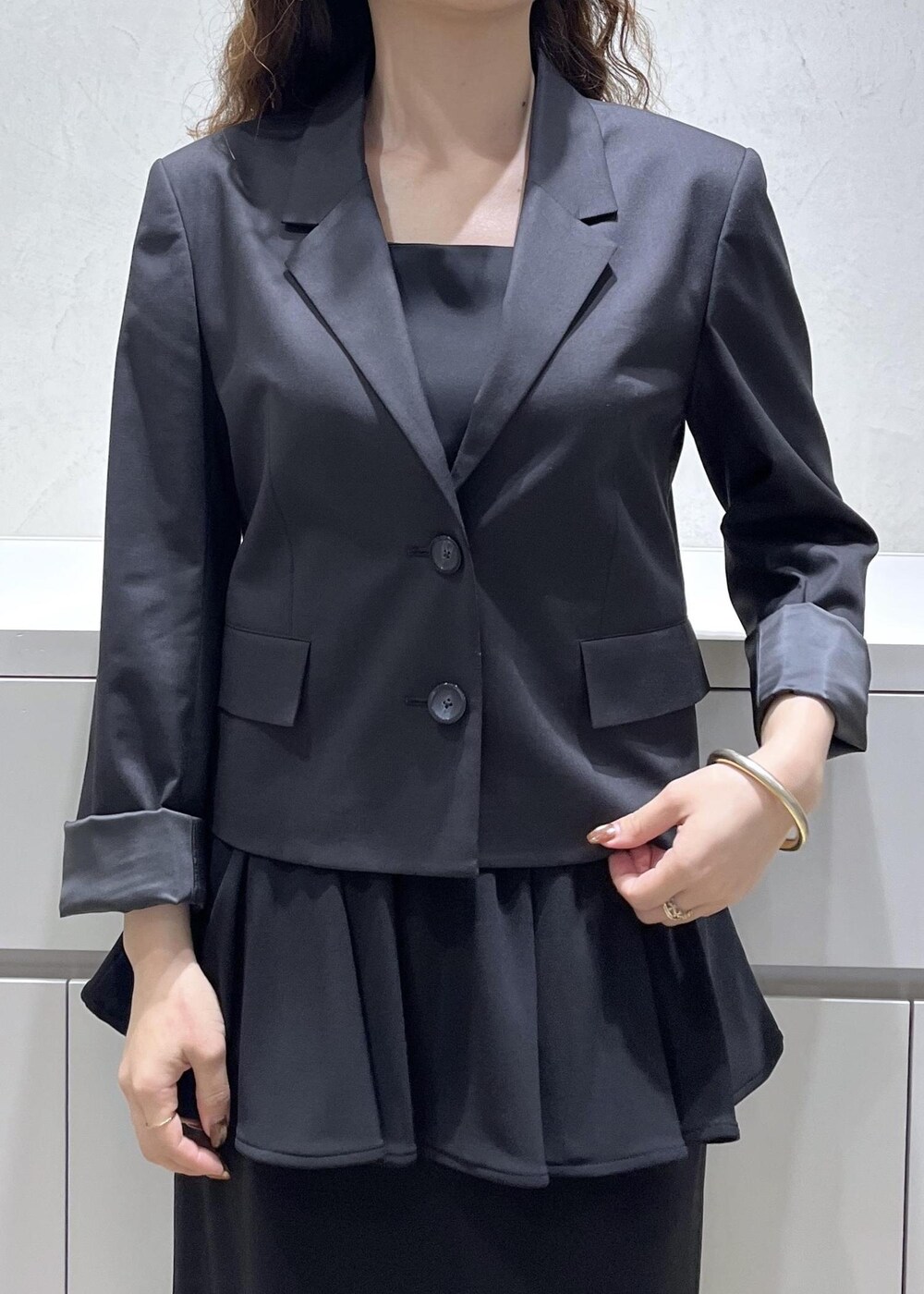 ブラック系のキャミソール、ブラック系のテーラードジャケット、ブラック系のスカートを着用したレディースの秋コーディネートの5枚目の写真