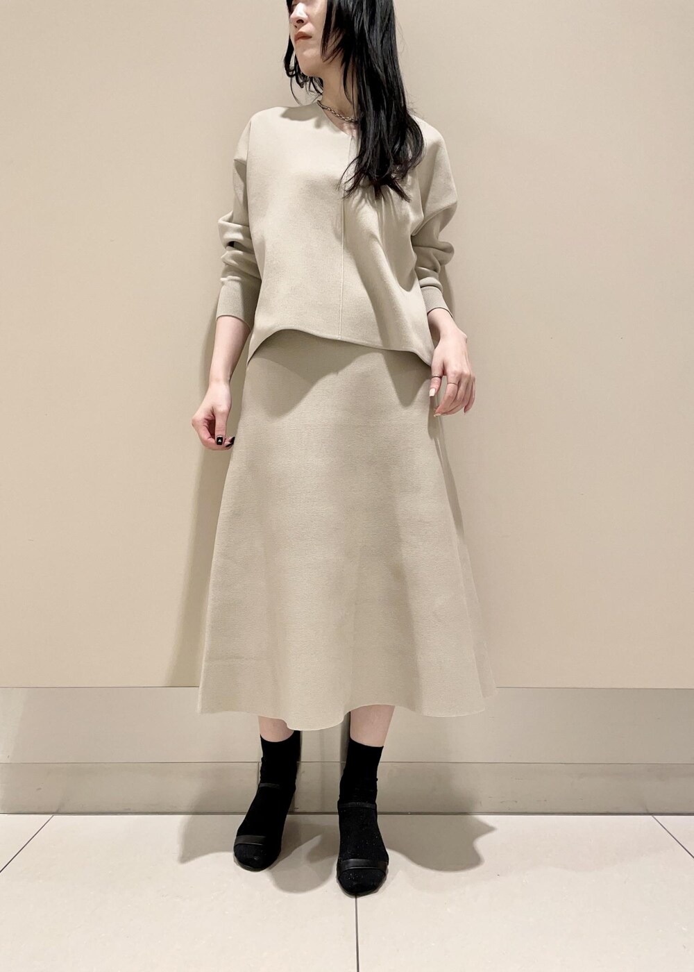 ブラウン系のショルダーバッグ、ベージュ系のスカート、ベージュ系のニット/セーターを着用したレディースの冬コーディネートの4枚目の写真