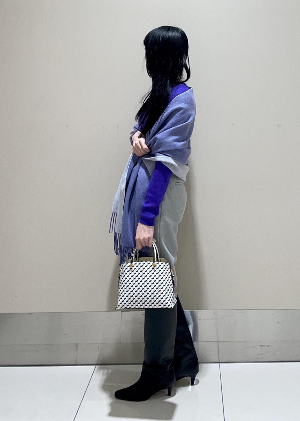 ホワイト系のショルダーバッグ、ブラック系のブーツ、グレー系のその他パンツを着用したレディースの冬コーディネートの2枚目の写真